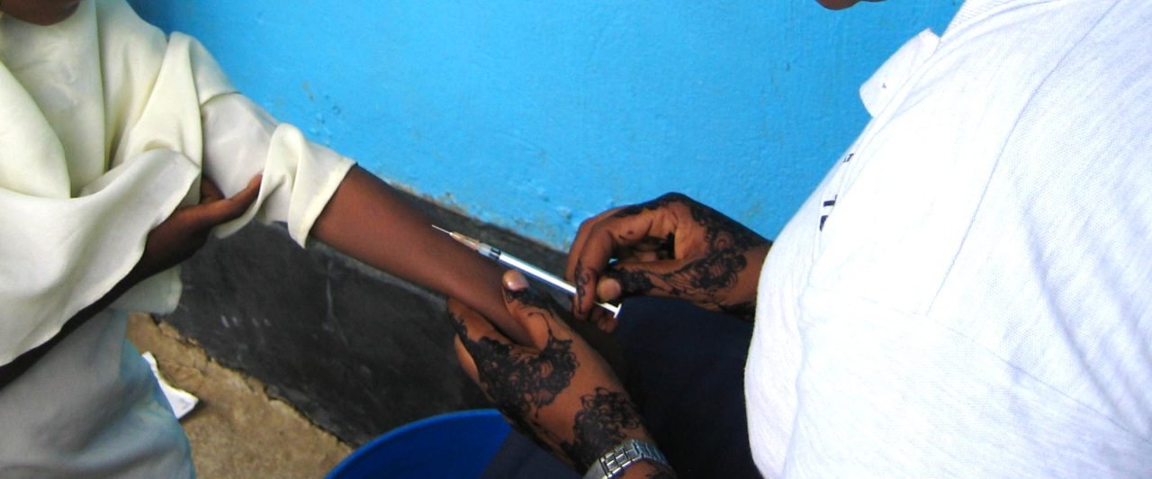 A health worker administering a TB skin test